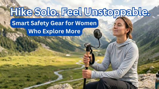 Female hiker holding SmartstickX walking stick with fan on mountain trail.